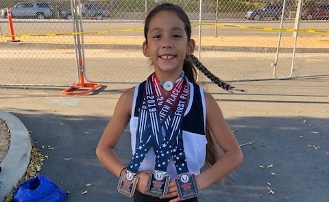 Student runner showing prize medals