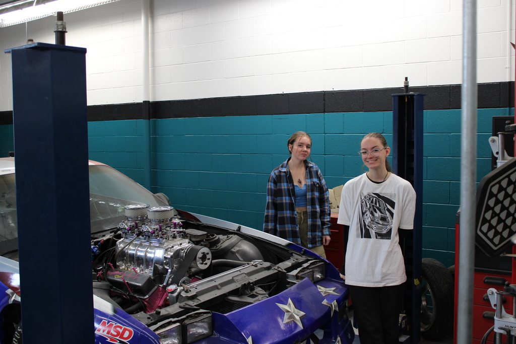 Students posing with a race car